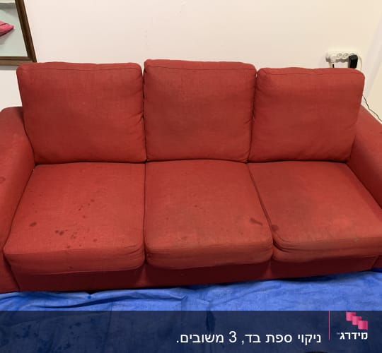 ספה אדומה עם כתמים על בד כחול